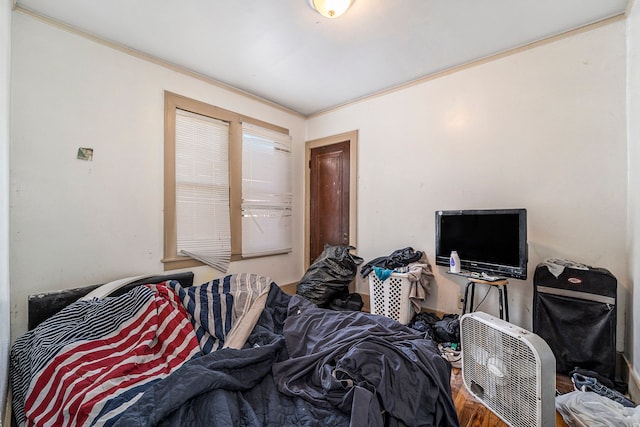 bedroom featuring crown molding and wood finished floors