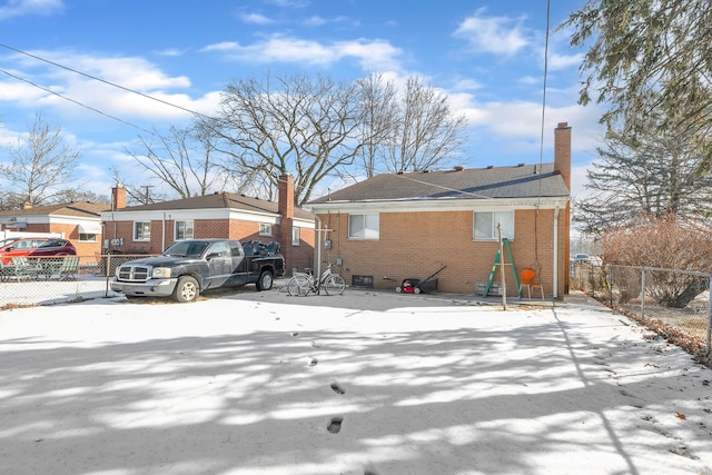 view of front of property with brick siding, fence, and a chimney