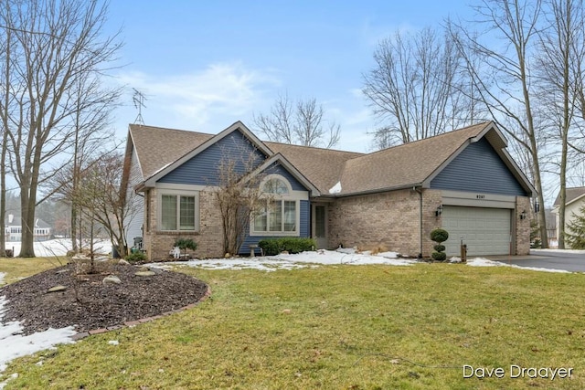 view of front of home with a garage, driveway, a front lawn, and brick siding