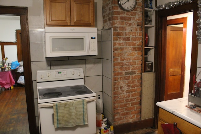 kitchen featuring white appliances, dark wood-type flooring, brown cabinetry, and light countertops