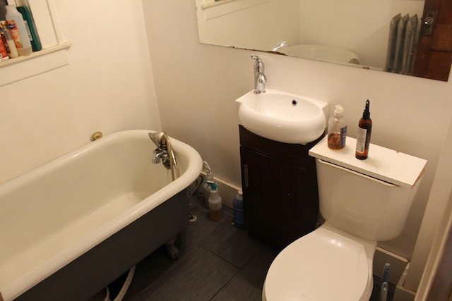 full bathroom featuring a freestanding bath, vanity, and toilet