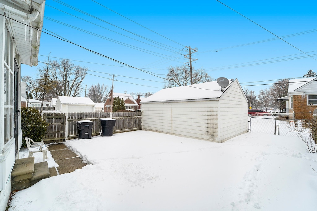 20248 Regent Dr, Detroit, MI 48205 - yard covered in snow with an outbuilding and fence