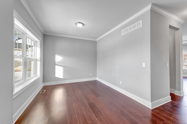 spare room with ornamental molding, visible vents, dark wood finished floors, and baseboards