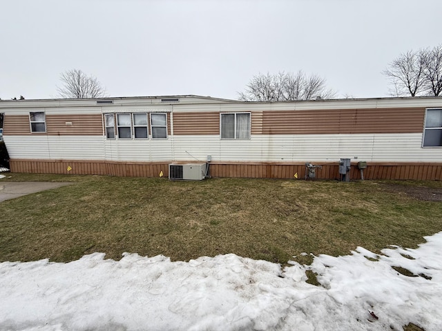 rear view of house with central AC and a yard