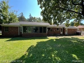 rear view of house featuring a lawn