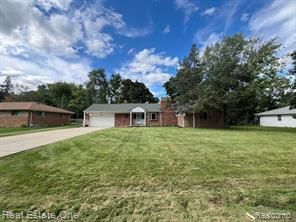 view of front of property with an attached garage, concrete driveway, and a front yard