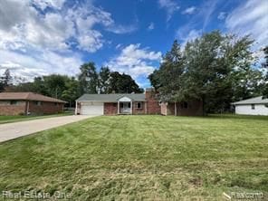 view of front of home featuring concrete driveway, a front lawn, and an attached garage