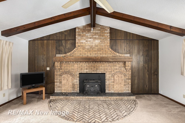 living area featuring carpet floors, wooden walls, lofted ceiling with beams, and a textured ceiling