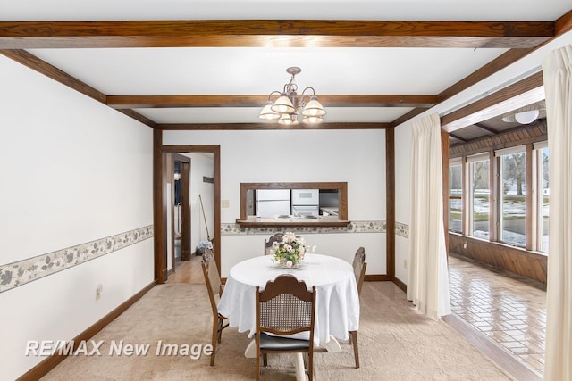 dining room with baseboards, a chandelier, beam ceiling, and light colored carpet