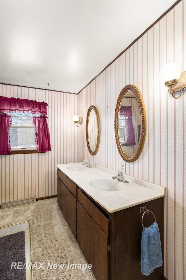 bathroom with double vanity, a sink, and wallpapered walls