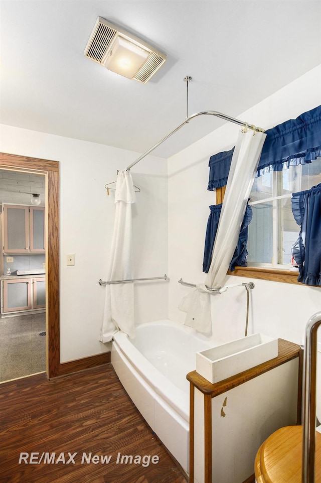 bathroom with shower / bath combination with curtain, visible vents, and wood finished floors