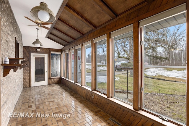 unfurnished sunroom featuring lofted ceiling, visible vents, and a ceiling fan