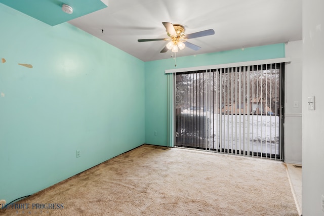 carpeted spare room with a ceiling fan