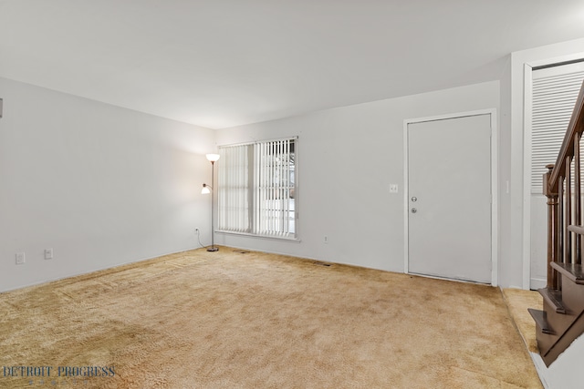 empty room with carpet floors and stairs