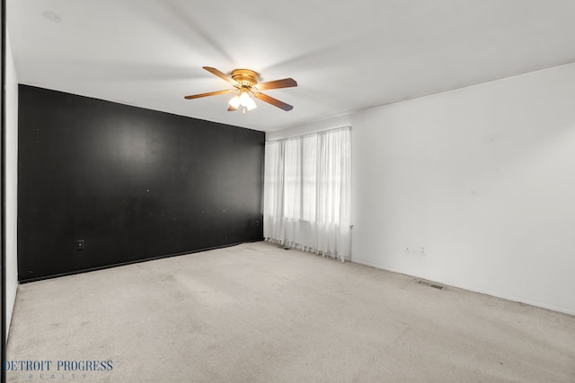 empty room with visible vents, ceiling fan, and carpet flooring