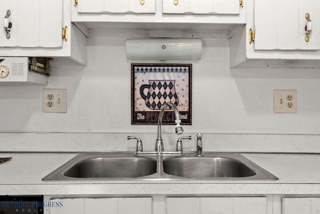 kitchen with light countertops, black dishwasher, white cabinetry, and a sink