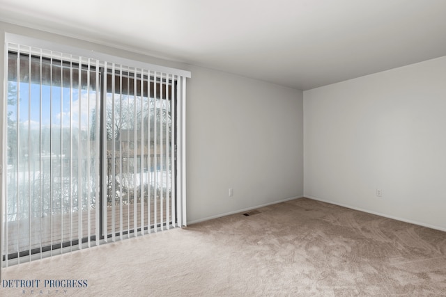 empty room featuring carpet floors and visible vents