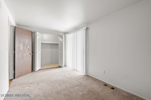 unfurnished bedroom featuring a closet, carpet flooring, and visible vents