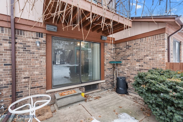 property entrance featuring brick siding