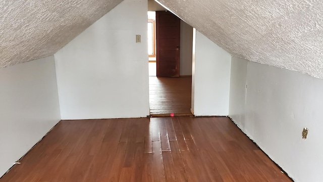 bonus room featuring vaulted ceiling, a textured ceiling, and hardwood / wood-style flooring