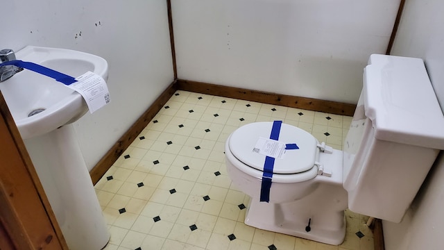 bathroom featuring baseboards and toilet