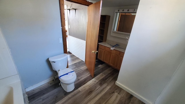 bathroom with vanity, wood finished floors, toilet, and baseboards