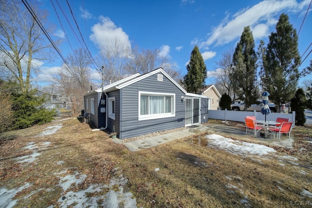 view of side of home with a patio area and fence