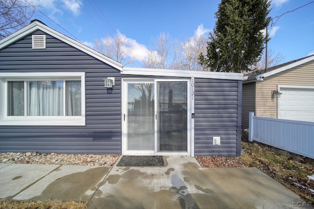 rear view of house with a patio area and an attached garage