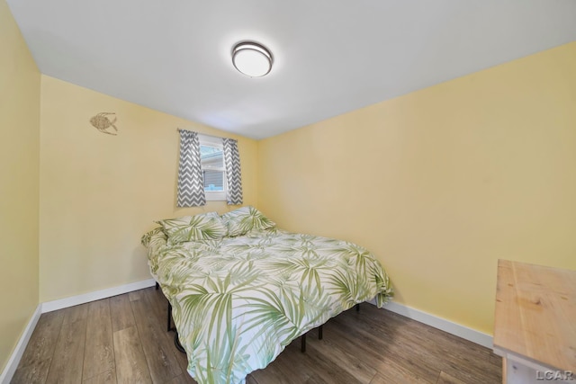 bedroom featuring baseboards and wood finished floors