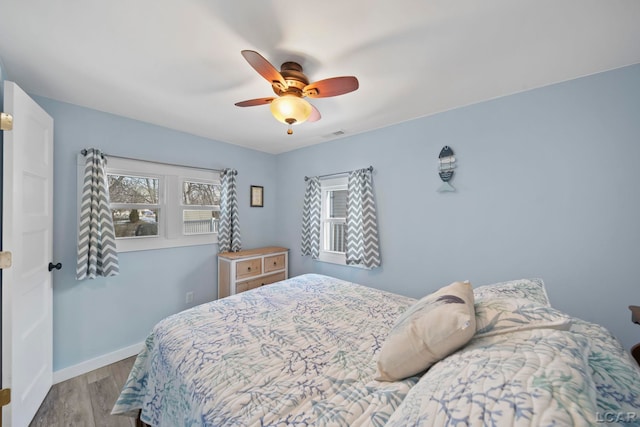 bedroom featuring ceiling fan, wood finished floors, and baseboards