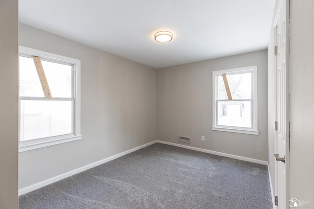 carpeted empty room with baseboards