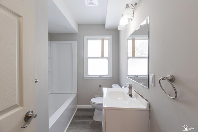 bathroom featuring toilet, wood finished floors, vanity, visible vents, and a bath