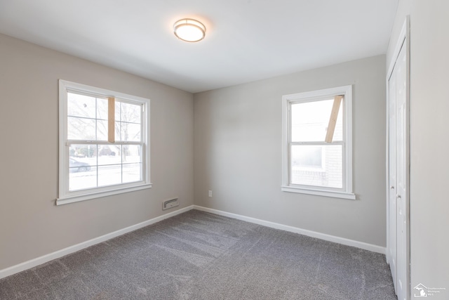 unfurnished room featuring carpet flooring and baseboards