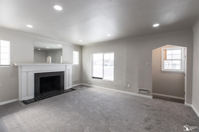 unfurnished living room featuring carpet, a fireplace, baseboards, and recessed lighting