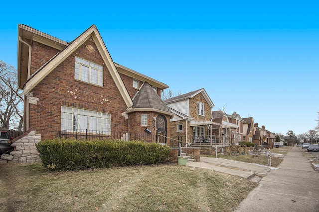 16636 Sorrento St, Detroit, MI 48235 - tudor-style house with a residential view, brick siding, and a front yard