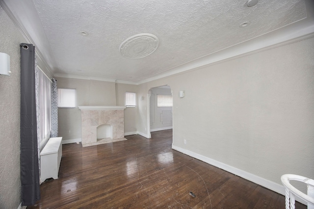 16636 Sorrento St, Detroit, MI 48235 - unfurnished living room featuring baseboards, a fireplace, arched walkways, ornamental molding, and wood-type flooring