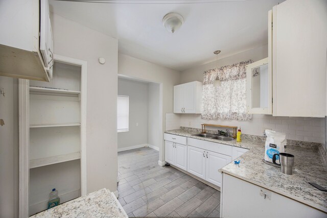 16636 Sorrento St, Detroit, MI 48235 - kitchen featuring backsplash, white cabinets, light wood-type flooring, and a sink