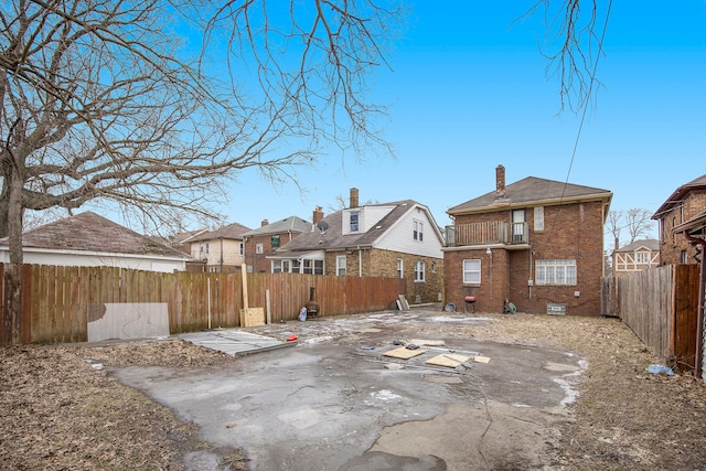 16636 Sorrento St, Detroit, MI 48235 - back of house featuring brick siding, a balcony, a chimney, and a fenced backyard