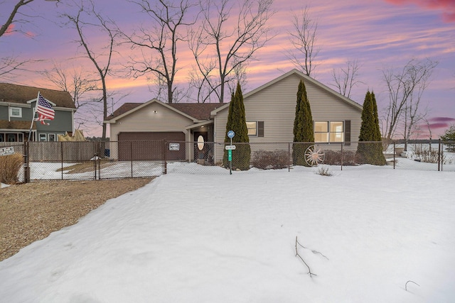 view of front of property featuring a garage, driveway, and a fenced front yard