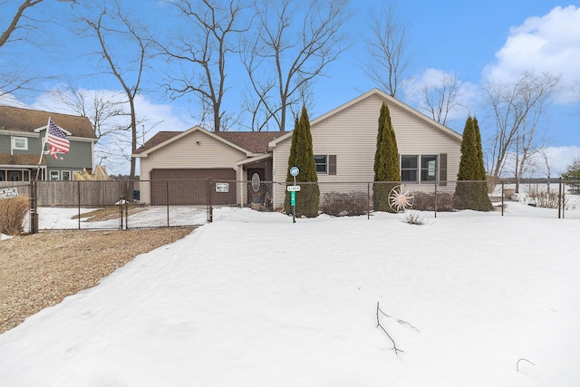 view of front of property with a garage, driveway, and a fenced front yard