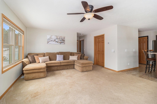 living area featuring carpet floors, a ceiling fan, and baseboards