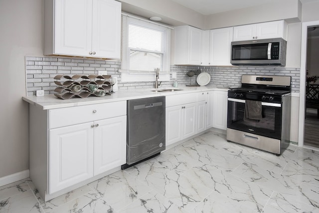 kitchen featuring stainless steel appliances, marble finish floor, light countertops, and a sink