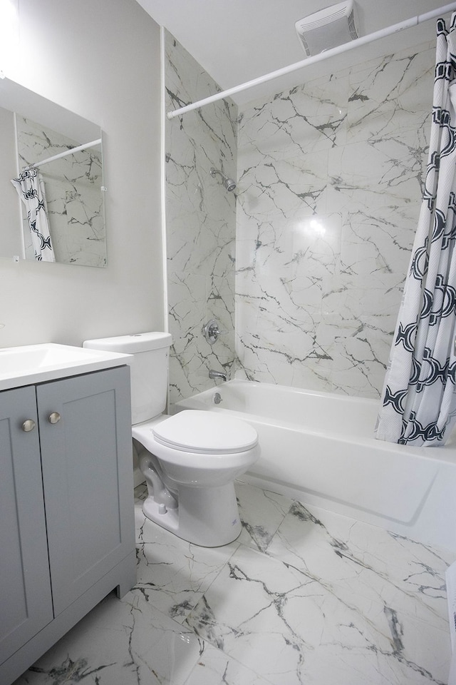 bathroom with toilet, marble finish floor, shower / tub combo, and vanity