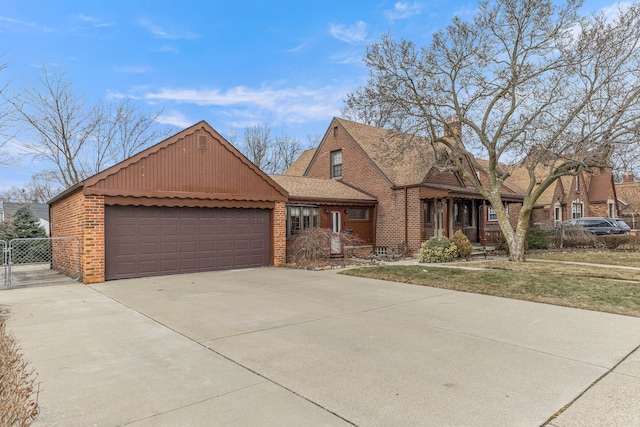 view of front of home with a garage, a shingled roof, a gate, fence, and brick siding