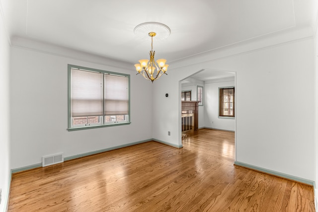 interior space with an inviting chandelier, baseboards, visible vents, and wood finished floors