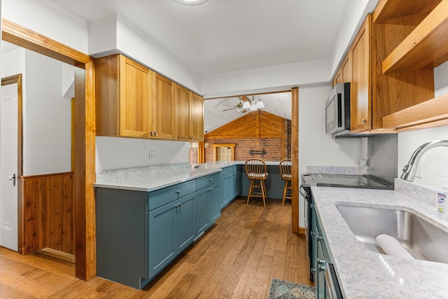 kitchen with range with electric stovetop, a sink, light wood-type flooring, open shelves, and stainless steel microwave