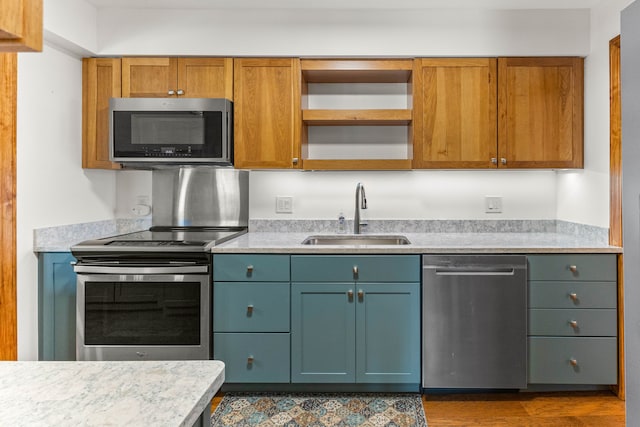 kitchen with appliances with stainless steel finishes, light countertops, and a sink