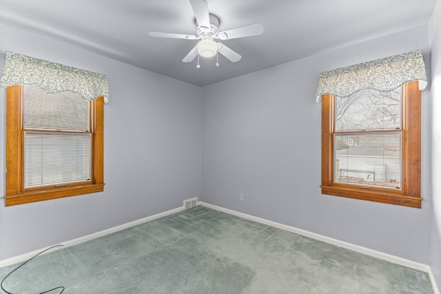 empty room featuring carpet floors, visible vents, baseboards, and a ceiling fan