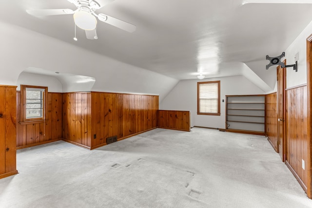 additional living space featuring wooden walls, visible vents, and a wealth of natural light