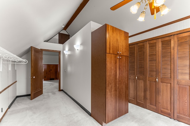 interior space with lofted ceiling with beams, baseboards, and light colored carpet